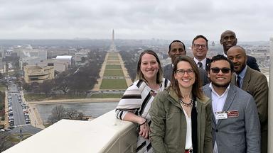 A group of policy fellows stand outside the US Capitol dome