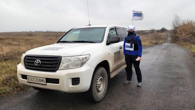 Colleen Ryan standing next to a car on patrol in Ukraine