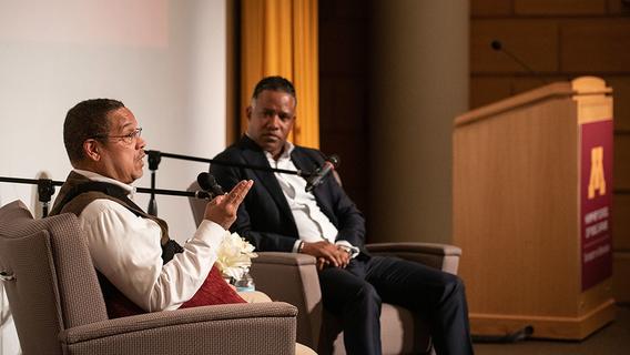 Keith Ellison and Kenneth Polite sitting in chairs on stage at the Humphrey School